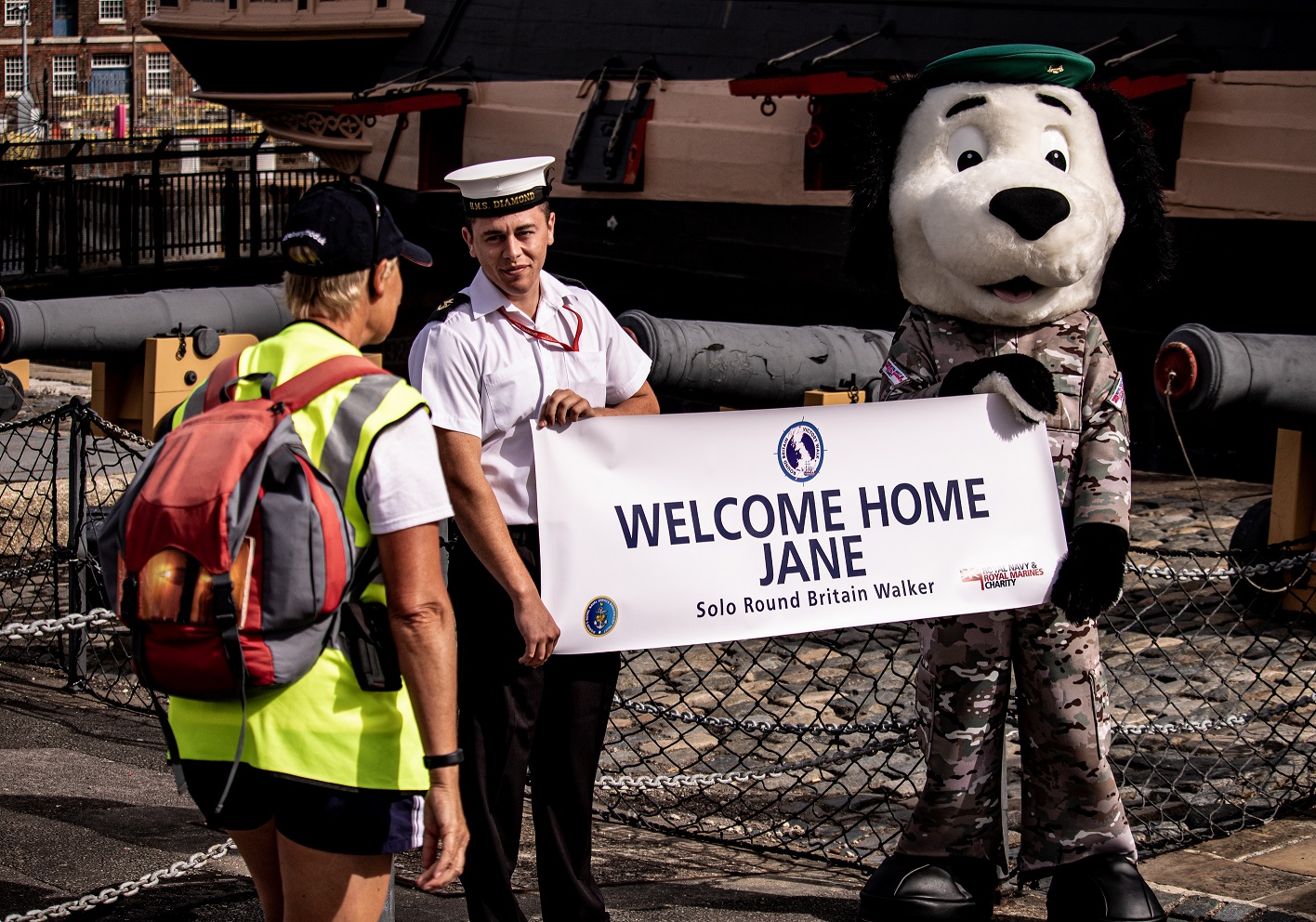 Jane greeted at HMS Victory by RNRMC Mascot Boots the Dog
