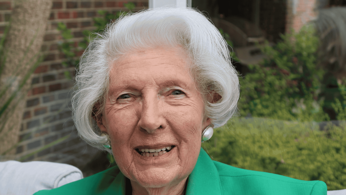 Lady sat looking into camera, smiling
