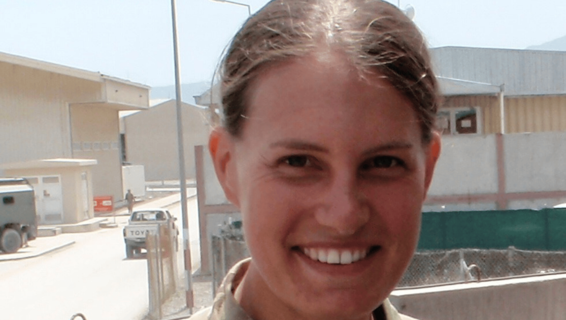 Lady looking directly into the camera wearing camouflage. 