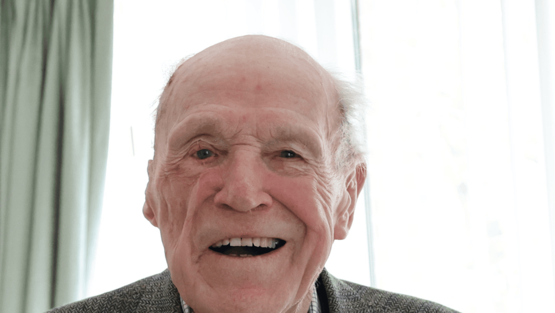 Man sat looking at the camera, smiling