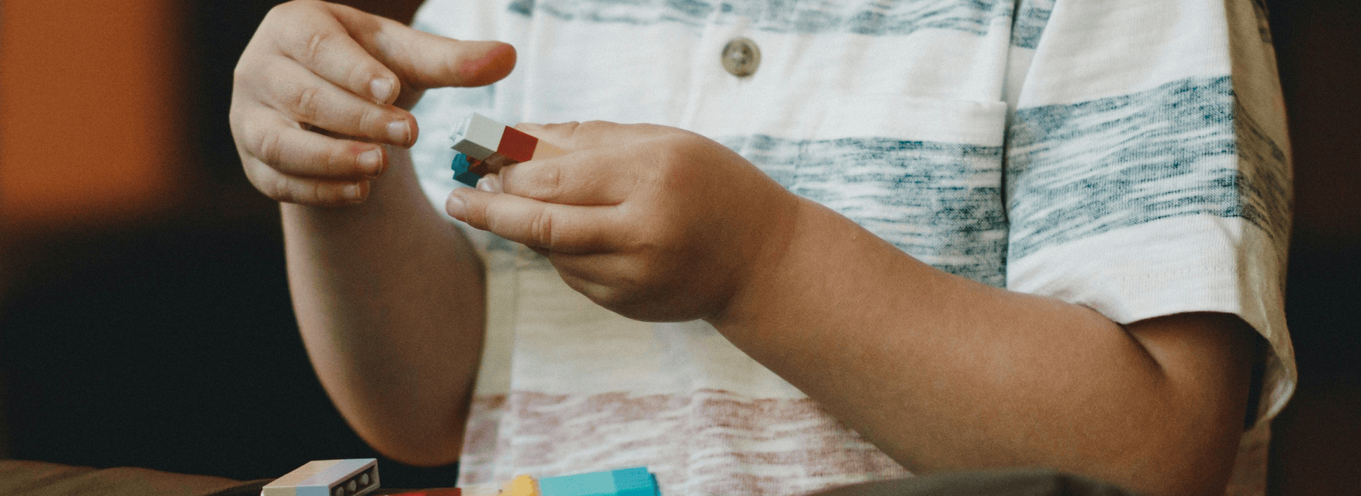 Small child playing with Lego.
