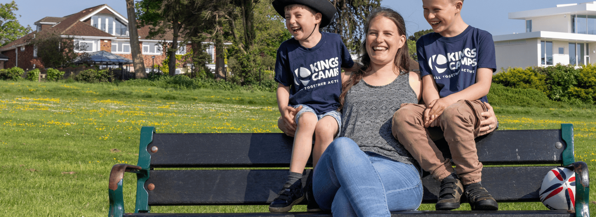 Lady with two children sat on a bench in a park