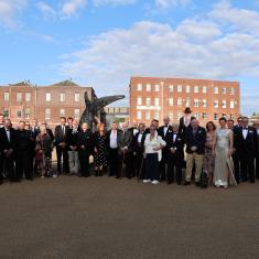 Group photo of people in formal dress inside the Historic Docyard in Portsmouth