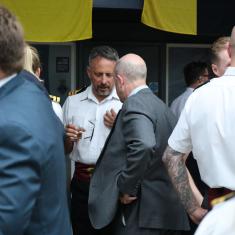 men in suits and naval dress talking