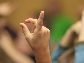 Small child's hand raised as if to ask  question.