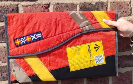 Front of case. Red and black laptop case. Camo and yellow strap. Life raft features.