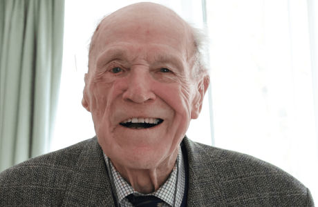Man sat looking into camera, smiling