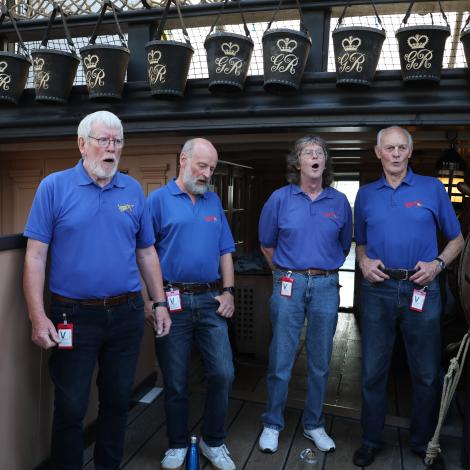 Portmosuth sea shanty men on the deck of HMS Victory
