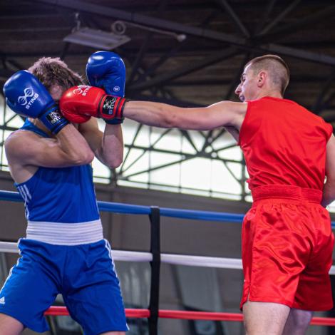 man in blue and man in red boxing in a boxing ring.