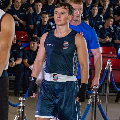 Royal Navy boxer walking red carpet in gym looking focused. 