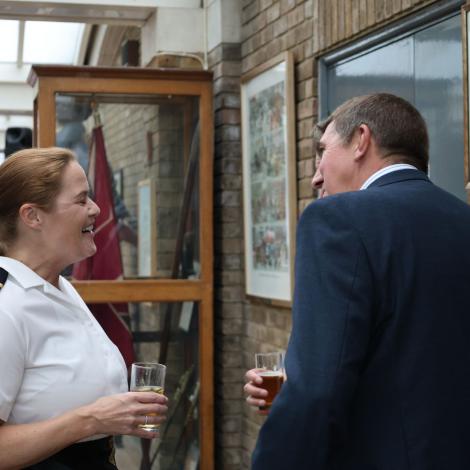 woman in naval dress talking to a man in a blue suit