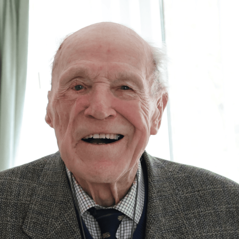 Man sat looking into camera, smiling