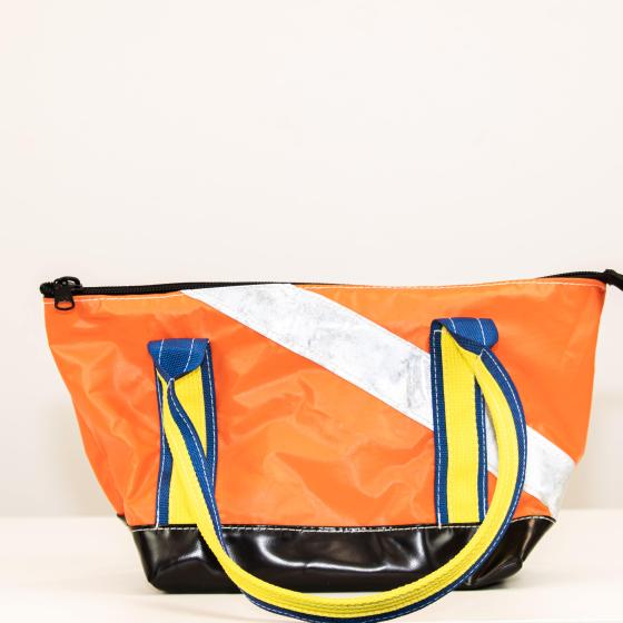 Right side of bag. Orange with silver strap and yellow and blue handles.