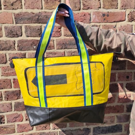 Yellow bag with yellow life raft feature and bright green and blue strap