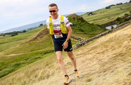 man climbing hill in sportswear as part of a running challenge