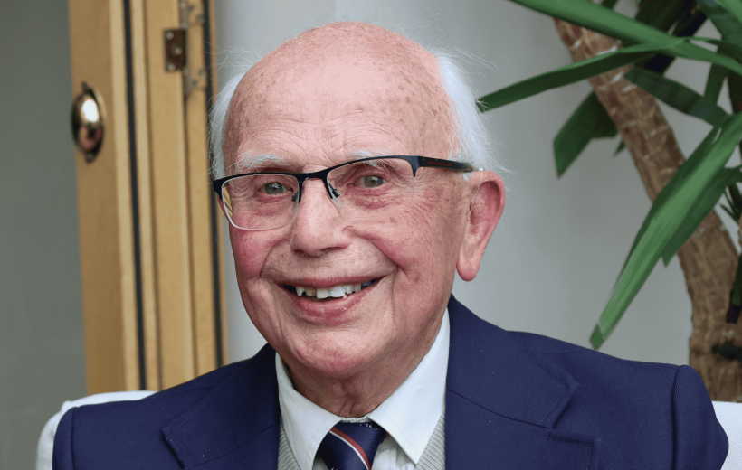 Man sat looking into camera, smiling