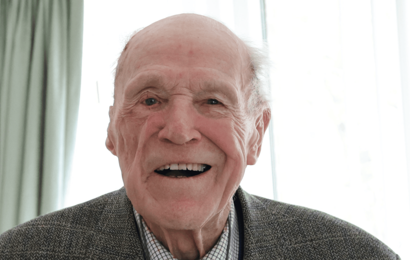 Man sat looking into camera, smiling